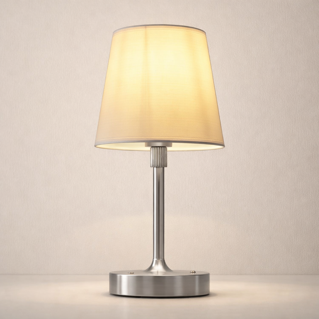 Table lamp with beige shade and metallic base on a neutral background