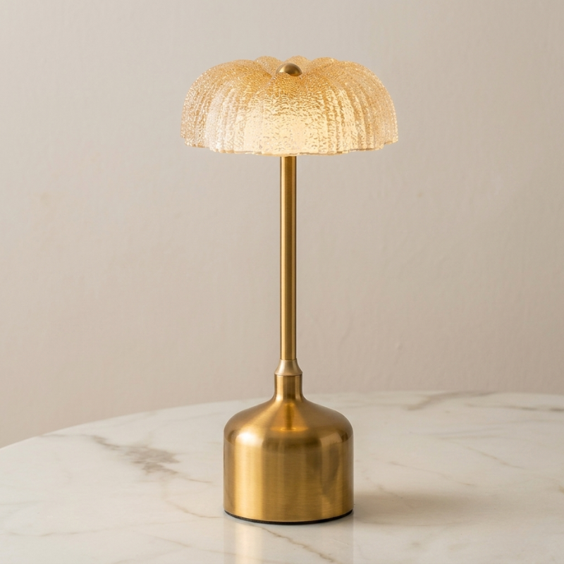 Gold table lamp with textured shade on a marble surface