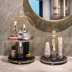 Two gold and black decorative stands with skincare products against a marble wall.