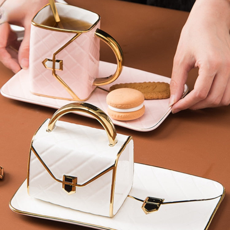 Teacup with gold handle, cookies, and macaron on a brown surface