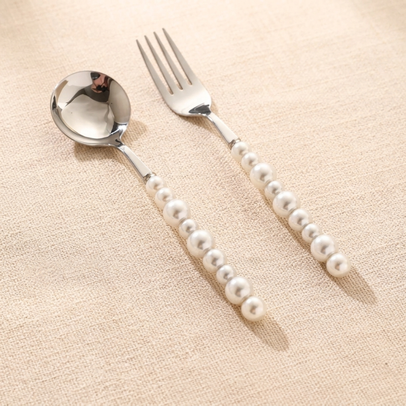 Spoon and fork with pearl handle on a beige background