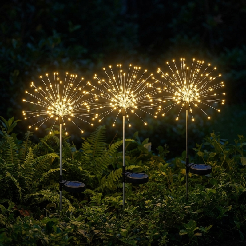 Three solar-powered fiber optic dandelion garden lights glowing with warm yellow light in a dark garden setting.