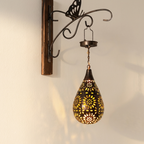 Decorative wall light fixture with intricate design on a neutral background