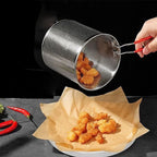 Metal strainer being used to transfer fried food onto a paper towel-lined plate.