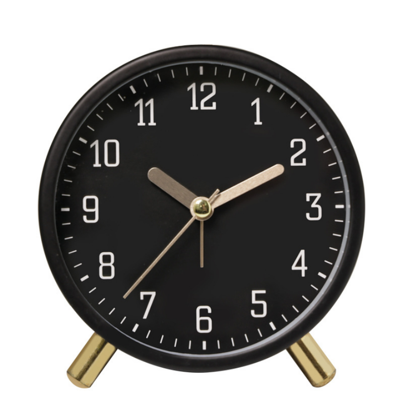 Black alarm clock with gold hands on a white background