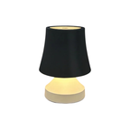 Table lamp with black shade and beige base on a white background