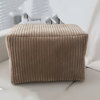 Beige ribbed ottoman on a light-colored floor with a neutral background