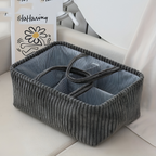 Gray corduroy storage basket with a striped interior on a light surface.