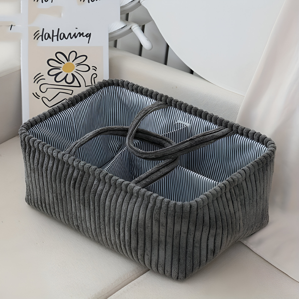 Gray corduroy storage basket with a striped interior on a light surface.