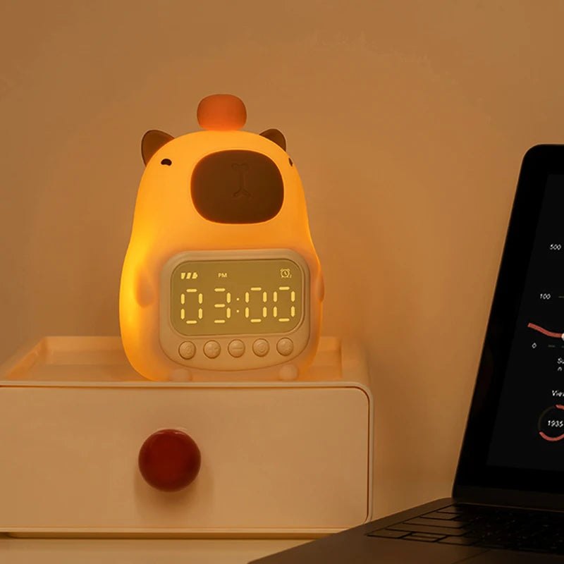 Cute animal-shaped night light with digital display on a wooden surface next to a laptop.