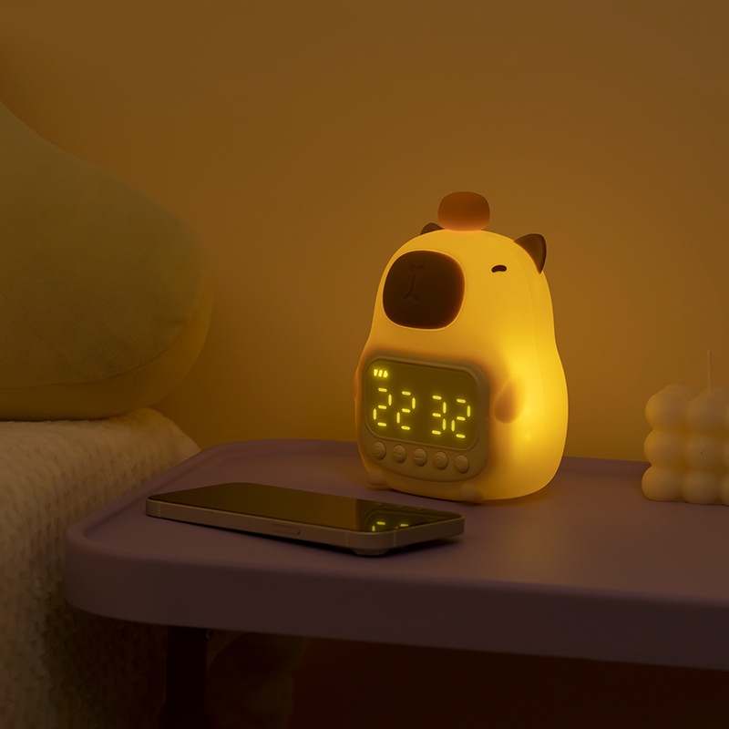 Yellow cartoon-style alarm clock on a nightstand with a smartphone, in a dimly lit room.