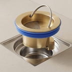 Brass kitchen sink strainer with blue rubber ring on a stainless steel sink.