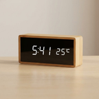 Digital clock with wooden frame displaying time and temperature on a beige background