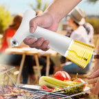 A hand holding a white electric oil sprayer bottle with a clear cap showing yellow oil inside, positioned over a grill with food and an outdoor barbecue scene in the background.