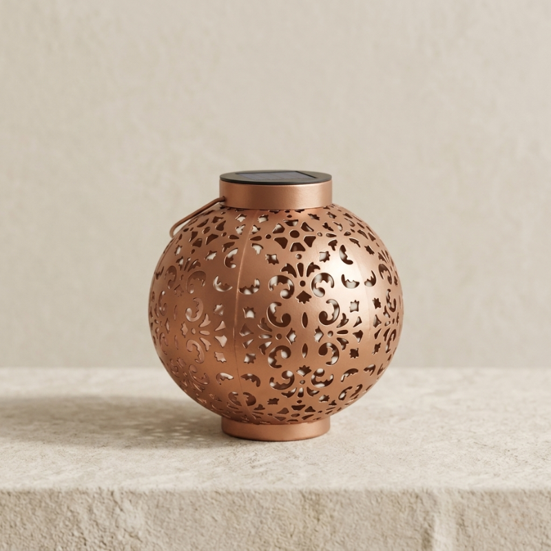 Decorative copper lantern with intricate patterns on a beige background