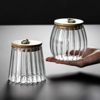 Two glass jars with wooden lids on a reflective surface