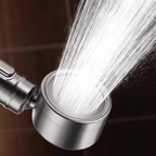 Metallic shower head with water spraying out against a dark background