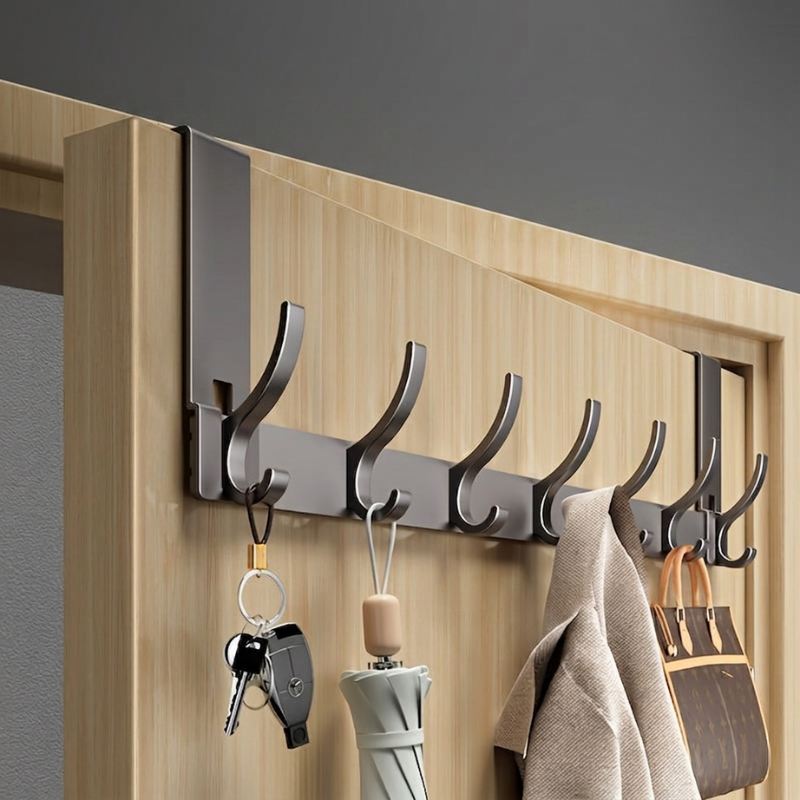 Wall-mounted hook rack with keys, umbrella, and bags on a wooden door.