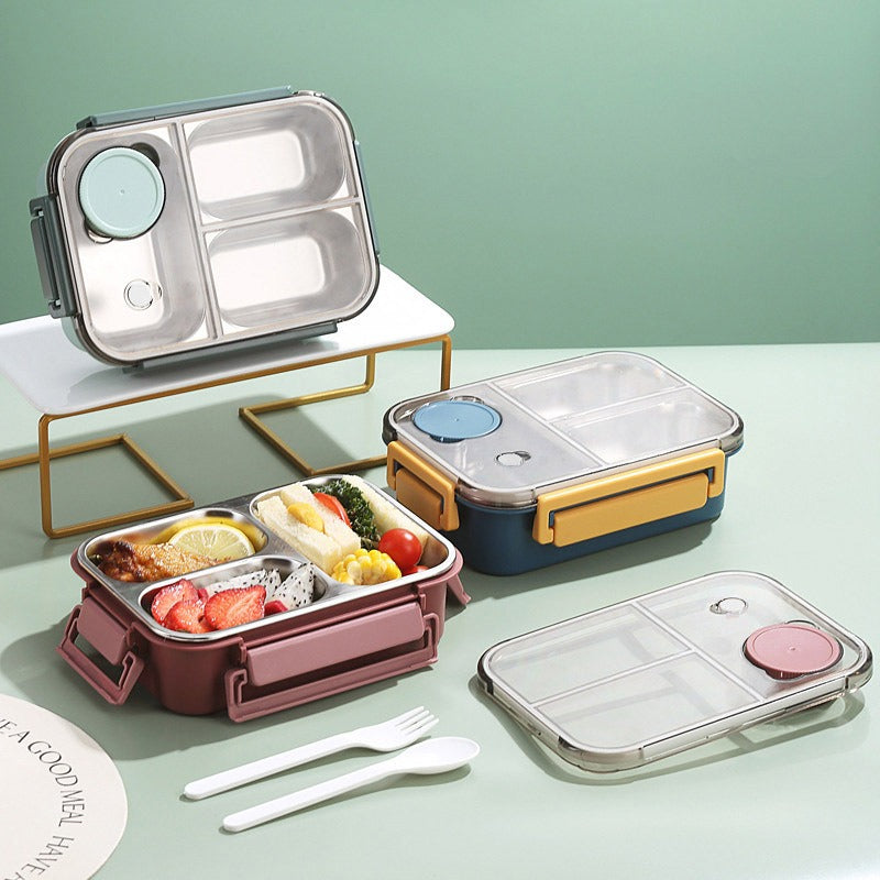 Set of lunch boxes with compartments and utensils on a light green background
