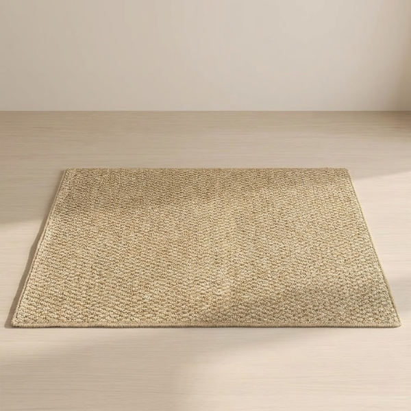 Beige woven mat on a wooden floor with a neutral background