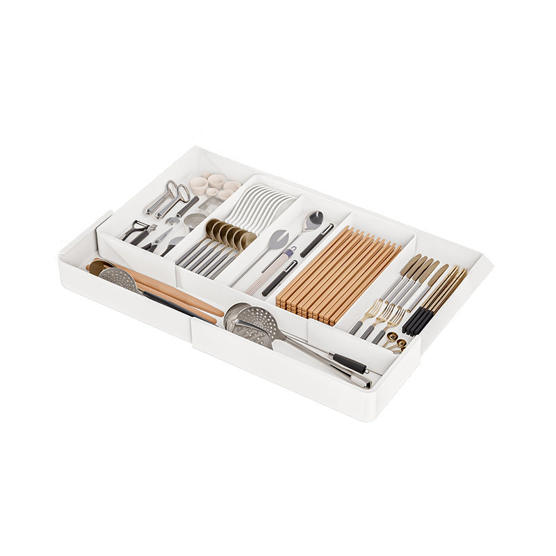 Set of cutlery and chopsticks in a white organizer on a white background