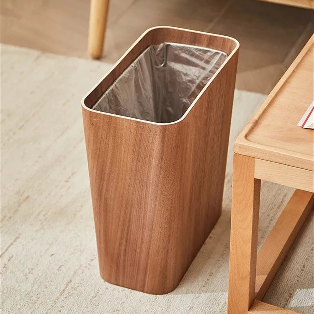 Wooden trash bin with a metallic liner on a carpeted floor.