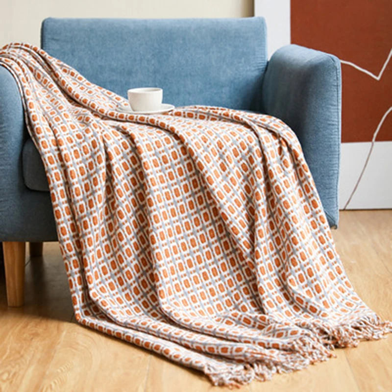 Patterned blanket draped over a blue armchair on a wooden floor.