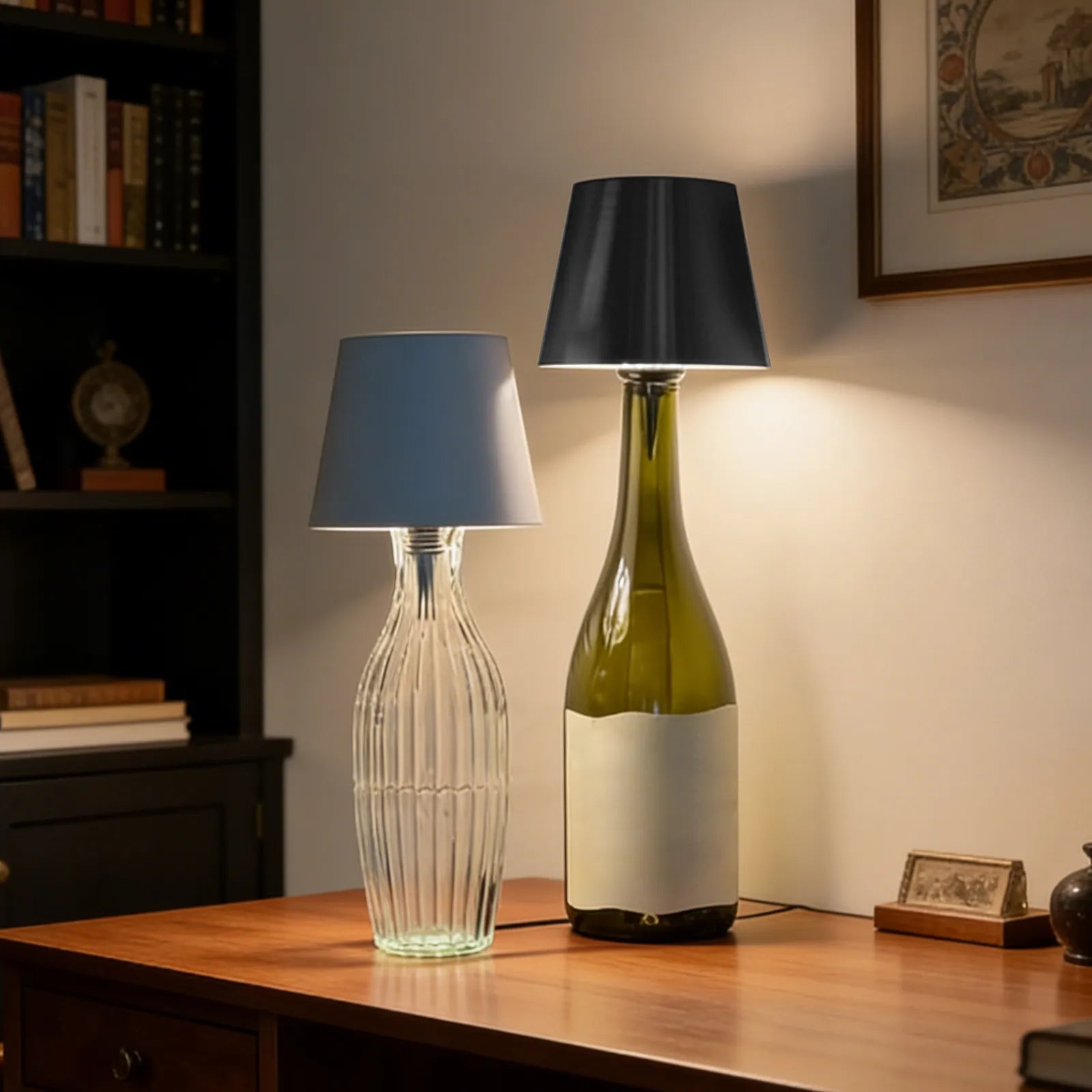 Two table lamps, one made from a clear glass bottle and the other from a green wine bottle, on a wooden surface.