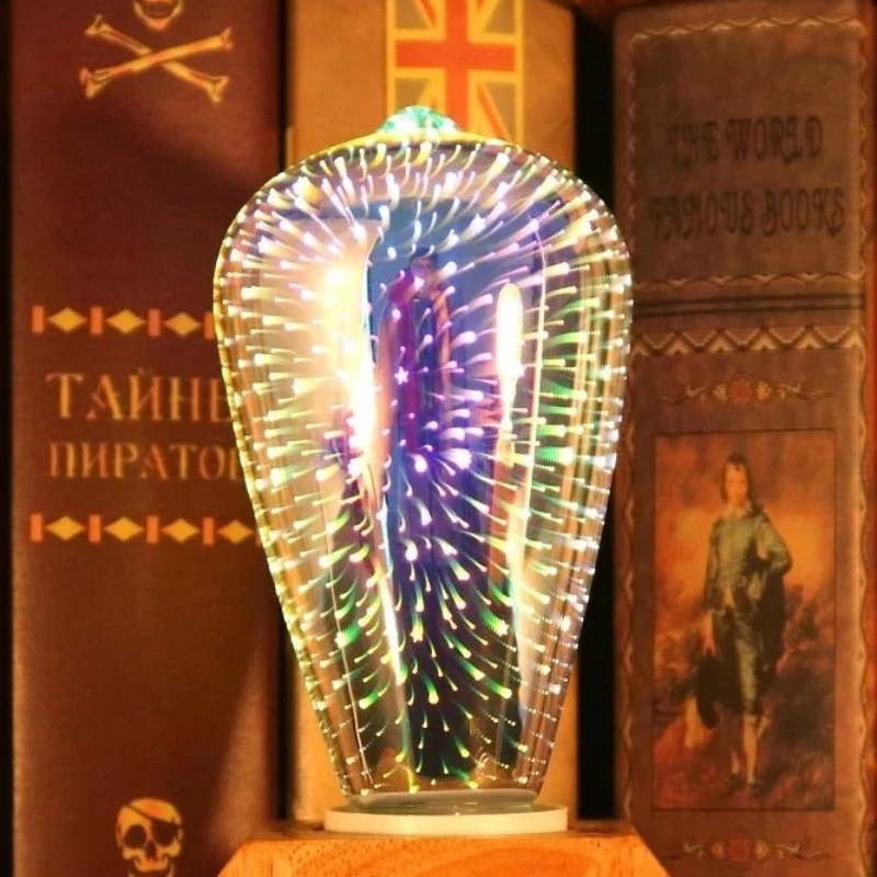 A decorative teardrop-shaped glass chandelier lamp glowing with multicolored LED lights, set against a dark, pirate-themed bookshelf background.