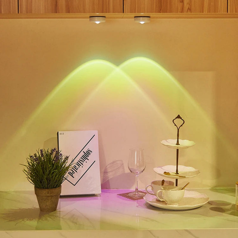 Decorative setup with a plant, book, glass, and tea set on a countertop with warm lighting.
