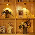 Wooden shelf with decorative items including a bust, flowers, and books.