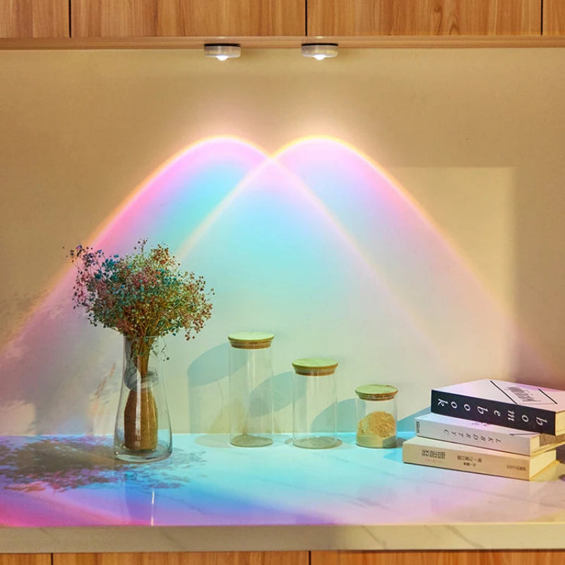 Decorative setup with a rainbow light effect on a surface, books, and small containers.