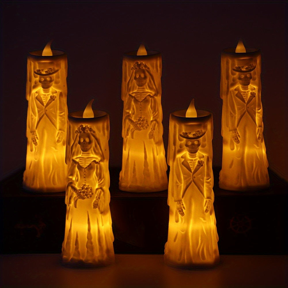 Five Halloween-style LED taper candles shaped like skeletons, including bride and groom figures, glowing with warm yellow light against a dark background.
