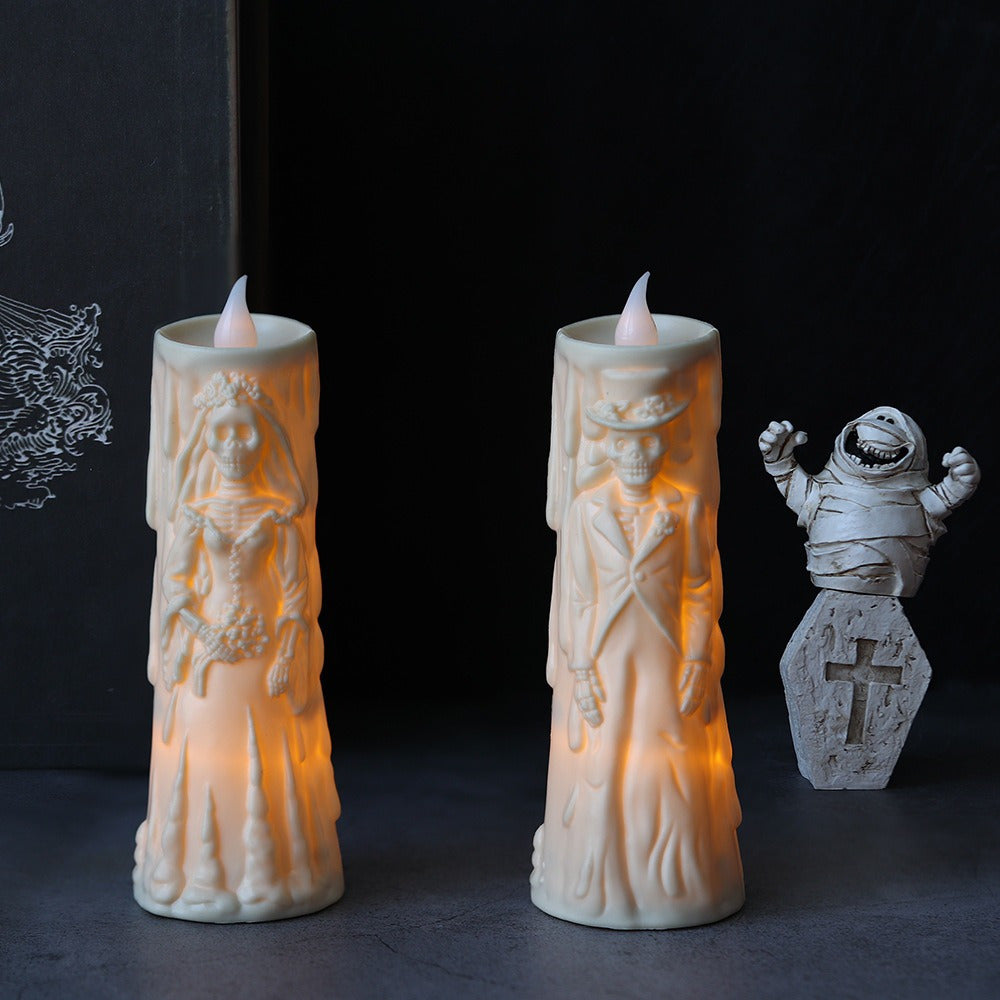 Two illuminated candle-shaped figures with a mummy figure in the background on a dark background