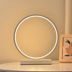 Round table lamp with circular LED light on a beige surface
