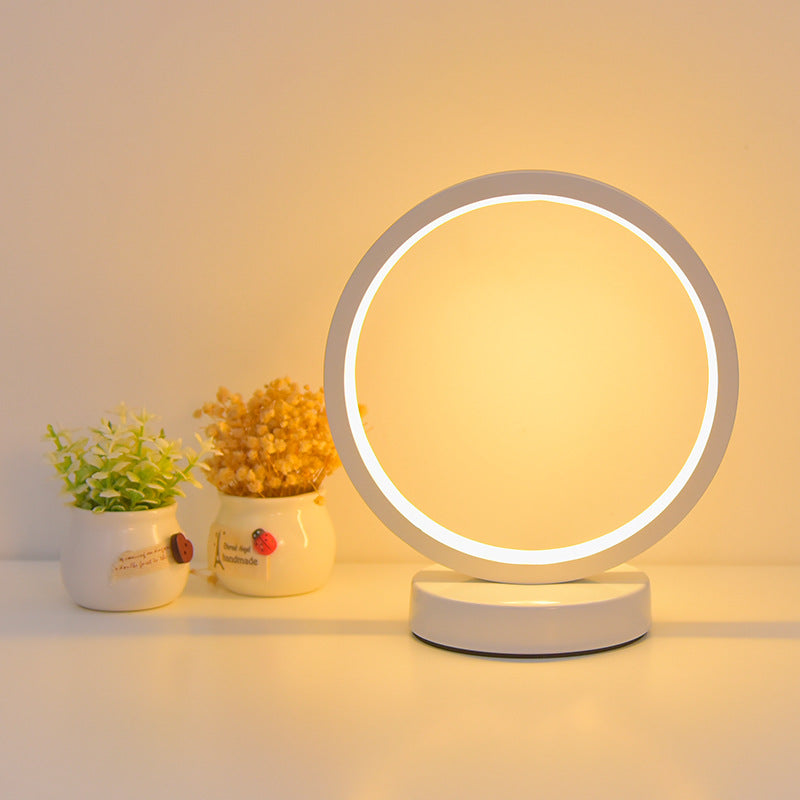 Round LED table lamp with a warm glow on a neutral background