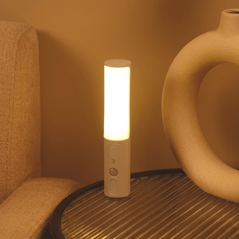 Portable light on a surface with a vase and chair in the background