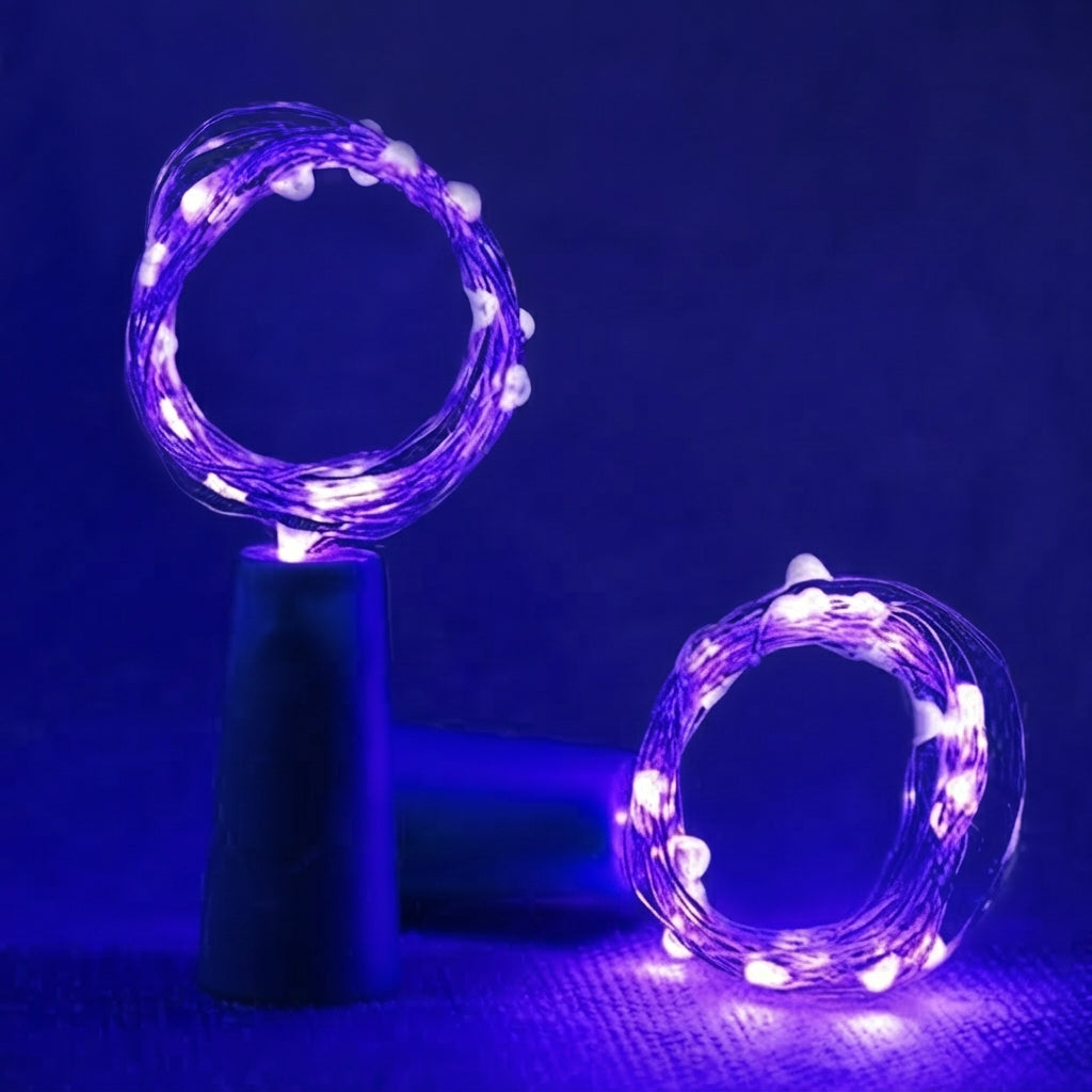 Purple LED fairy string lights arranged in two circular rings, one resting on a dark cylindrical stand and the other on a textured blue surface, set against a dark blue background.