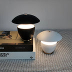 Two table lamps, one black and one white, on a textured surface with a magazine underneath.