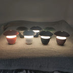 Set of small, colorful lamps on a textured surface with a dark background