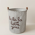 Storage basket with gray chevron pattern and brown text on a beige background