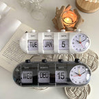 Dual clock with calendar display on a surface with a candle and book in the background