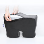Gray and black cushion with a person holding it on a white background