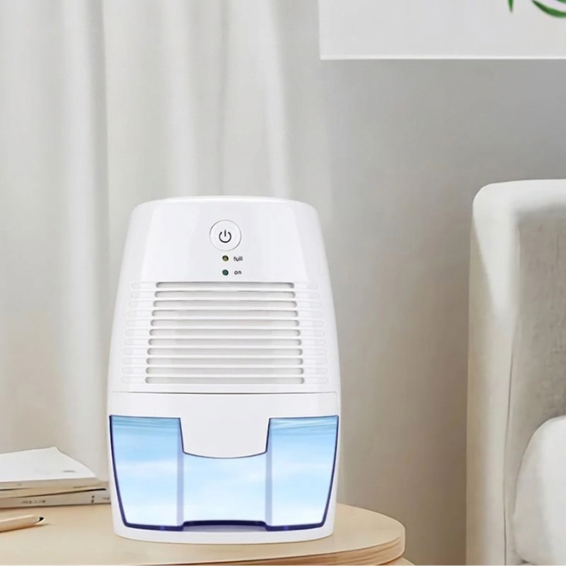 White dehumidifier with blue water tank on a wooden surface
