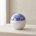 White spherical humidifier with blue floral design on a beige surface