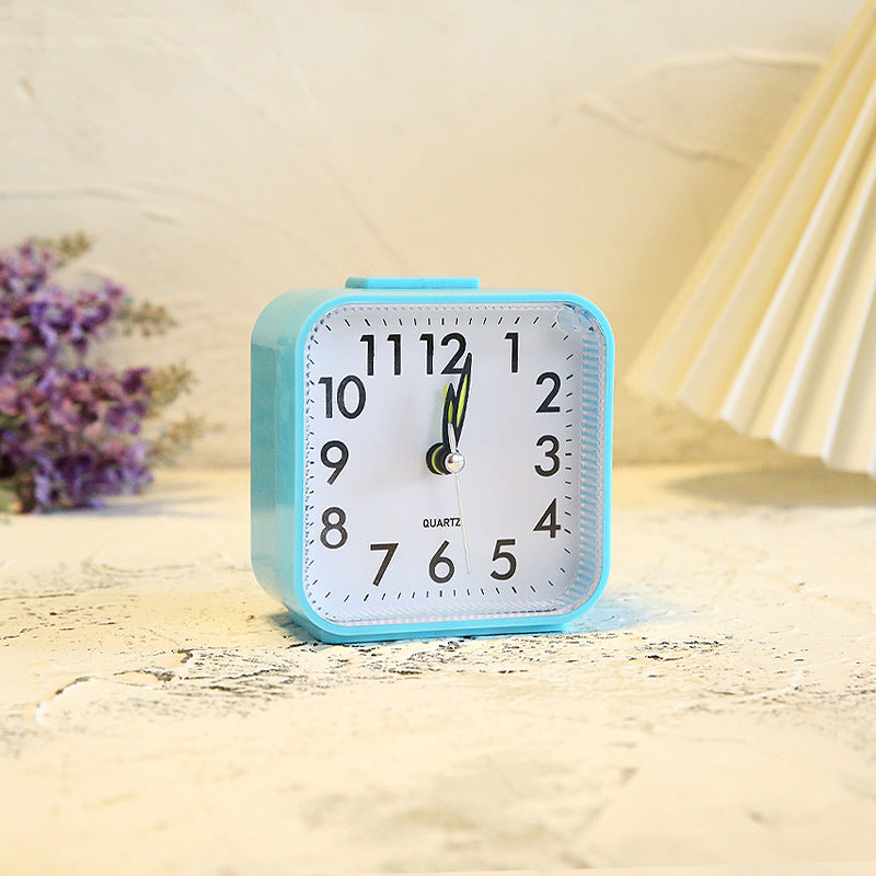 Blue alarm clock on a wooden surface with a soft focus background