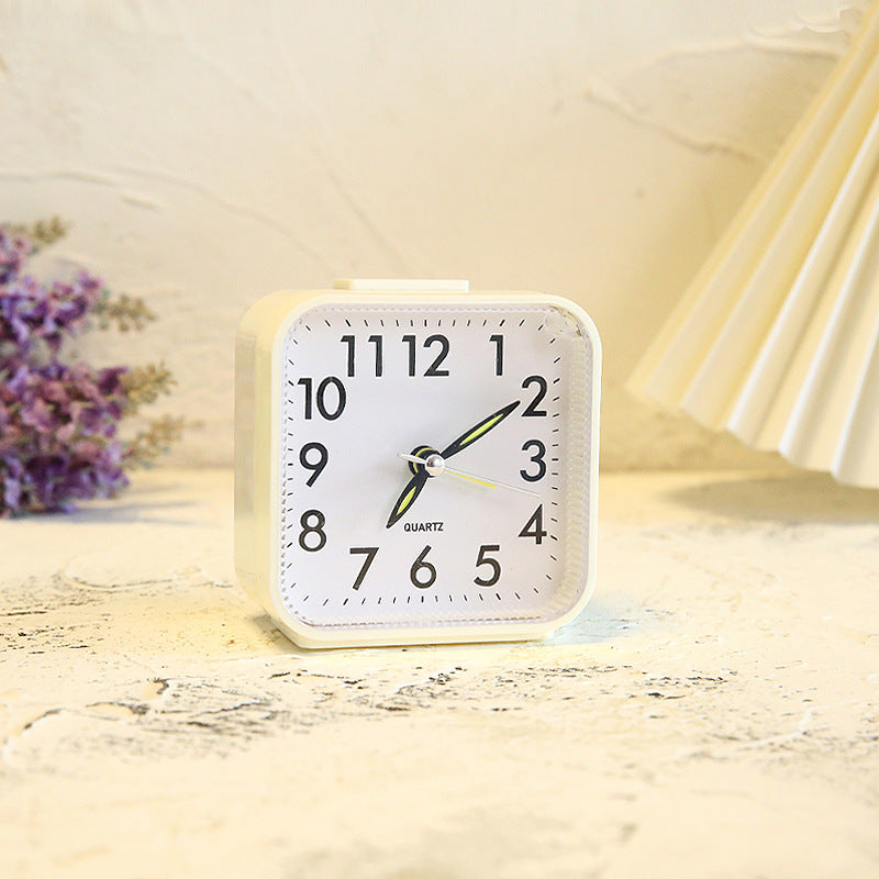 White alarm clock on a wooden surface with a soft focus background