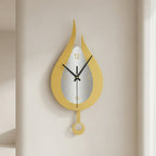 A modern flame-shaped wall clock in mustard yellow and white with black hands, mounted on a warm beige wall.