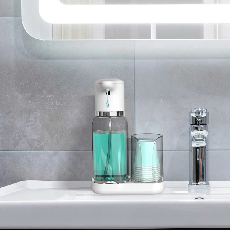 Bathroom setting with a soap dispenser, cups, and a faucet on a sink.