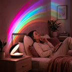 Woman lying on a bed with a colorful rainbow light projection in a cozy room.